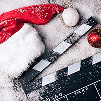 Santa hat in the snow with a movie scene board.